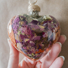 Load image into Gallery viewer, Large (3.5 inches wide by 4 inches tall) glass heart filled with dried orange lilies, pink rose petals, baby&#39;s breath and devil&#39;s ivy flower.
