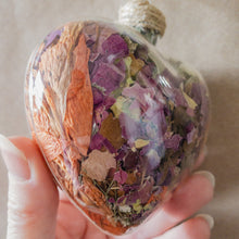 Load image into Gallery viewer, Large (3.5 inches wide by 4 inches tall) glass heart filled with dried orange lilies, pink rose petals, baby&#39;s breath and devil&#39;s ivy flower.
