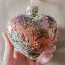 Load image into Gallery viewer, Large (3.5 inches wide by 4 inches tall) glass heart filled with dried orange lilies, pink rose petals, baby&#39;s breath and devil&#39;s ivy flower.
