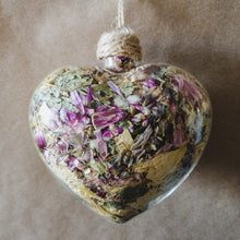 Load image into Gallery viewer, 3.5&quot; wide x 4&quot; tall glass heart filled with dried pink strawflower, white roses and green hydrangea.
